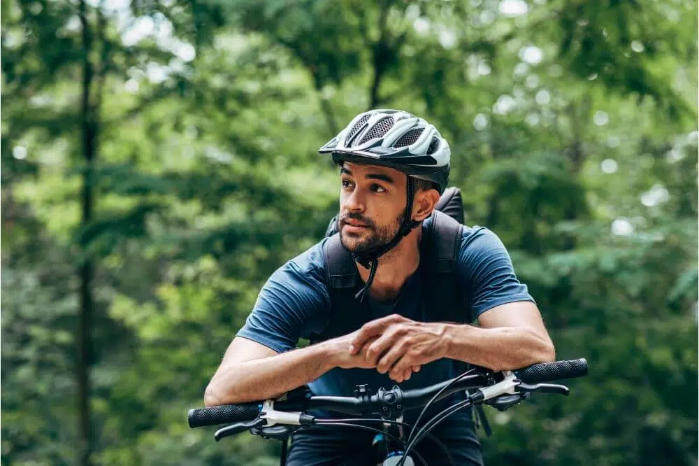 How to Adjust Bike Helmet Straps 2 Man standing on a bike with helmet