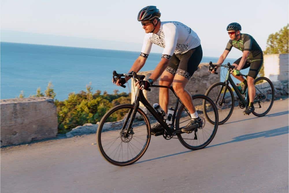 How to Measure Bike Helmet Size 2 Two men riding a bike near the sea with helmets